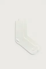 Medias de algodón color blanco crudo, con diseño acanalado en toda la prenda y acabado elástico en el puño.