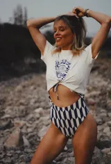 Traje de baño entero de lycra estampada, con diseño geométrico de rombos en azul marino y blanco. Presenta escote delantero con abertura central regulable y breteles ajustables.