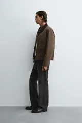 Cazadora de corte relajado con acabado efecto encerado, cuello de solapa en pana, manga larga y bolsillos frontales de plastrón con solapa. Presenta cierre frontal de cremallera oculta por solapa con botones a presión.