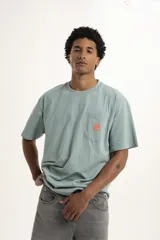 Remera color arena de corte holgado con bolsillo en el pecho y logo estampado en azul.