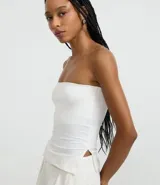 Blusa blanca sin breteles, confeccionada en microfibra, con detalle de encaje en el lateral y corte ajustado.