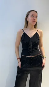 Top negro de tul con breteles finos y volado frontal.