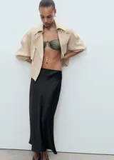 Falda midi evasé de tejido satinado color negro, con tiro medio y cintura elástica sin cierre.