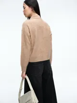 Sweater de tejido de punto suave con textura, cuello polo con cierre de tres botones, manga larga y corte recto.