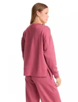 Buzo deportivo de cuello redondo, con hombros caídos y mangas largas con puños. Presenta costuras decorativas tipo pespunte en la parte frontal y en las mangas, con un diseño de ruedo recto y tajos laterales.