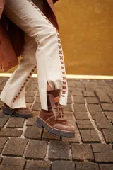 Borcegos de gamuza y terciopelo color azul marino, con detalles en color cobre y suela de goma negra. Cierre con cordones.