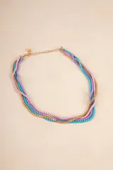 Collar corto con cadenas de eslabones dorados, turquesas, lilas y rosas entrelazadas.
