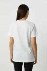 Remera de algodón color negro con cuello redondo y mangas cortas. Presenta un estampado frontal con diseño de rosas, rayos y texto, decorado con detalles de strass.
