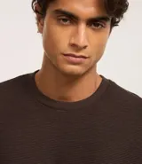 Remera color crema, de corte holgado, con cuello redondo y mangas cortas.