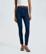 Pantalón skinny de tiro alto confeccionado en denim azul oscuro. Presenta un diseño clásico con cierre de cremallera y botón, trabillas para cinturón y bolsillos funcionales tanto en la parte delantera como en la trasera.