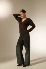Saco de punto con cuello en V y cierre frontal con botones. Presenta un diseño ajustado al cuerpo, manga larga y terminación acanalada en el ruedo.