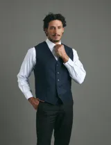 Chaleco de vestir color azul oscuro con textura sutil, corte clásico, cierre frontal con botones y bolsillos laterales simulados.