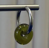 Aros tipo argolla de plata 925 con dije colgante en forma de dona de vidrio color verde musgo.