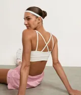 Top deportivo blanco de microfibra, con escote en V y diseño de doble tirante fino que se cruza en la espalda.