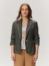 Blazer de lino color negro con pespuntes en contraste de hilo tostado, cuello solapa amplia, cierre frontal con un botón de madera y bolsillos aplicados.