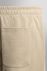 Pantalón jogger de corte relajado confeccionado en tejido compacto de algodón. Presenta cintura elástica con cordón interior, bolsillos frontales en la cadera y un bolsillo trasero de plastrón.