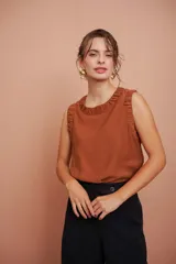 Blusa sin mangas color terracota, con escote redondo y detalles fruncidos en el cuello y las sisas.