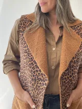 Chaleco largo con estampado animal print, forrado con corderito color camel y bolsillos delanteros.