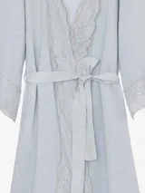 Kimono de lino color beige, de silueta fluida, con escote en V, mangas amplias, lazo para ajustar en la cintura y delicadas guardas de encaje en solapas y puños.