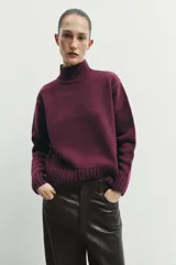 Jersey de punto liso con cuello subido, manga larga y acabados en rib en puños, cuello y ruedo.