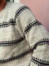 Sweater de punto con cuello redondo, diseño de rayas horizontales en tonos oscuros sobre base clara, de manga larga y calce cómodo.