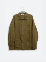 Chaqueta verde oliva de lino italiano, corte relajado, con tres bolsillos frontales y cierre con botones.