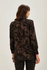 Camisa de modal con estampado abstracto en tonos oscuros y tierra, de corte clásico con cuello camisero, cierre frontal de botones y mangas largas con puños.