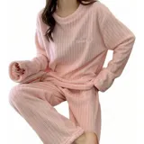 Conjunto de pijama de dos piezas confeccionado en tela de plush texturizada con diseño de rayas verticales en relieve. Incluye una remera de manga larga con cuello redondo y un pantalón de corte holgado. La remera presenta un pequeño bordado decorativo en el pecho.