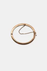 Set de tres pulseras metálicas de color dorado envejecido con detalles de brillos y dijes de estrellas.
