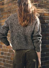 Cardigan de punto jaspeado con cierre frontal de cremallera, cuello perkins y manga larga.