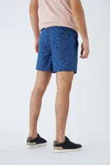 Short de baño con estampado de líneas curvas en tonos azules, cintura elástica con cordón ajustable, bolsillos laterales y bolsillo trasero. Incluye suspensor interno y logo bordado.