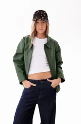 Campera de cuero color verde, con cierre frontal, cuello clásico y diseño de corte recto.