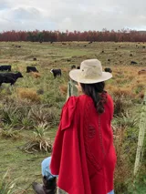 Capa roja de tejido de punto en lana con apliques en cuero y bordados.