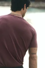 Remera deportiva de manga raglán y cuello redondo, color bordó, con diseño de tejido técnico texturizado y costuras planas, corte ajustado al cuerpo tipo muscle fit.