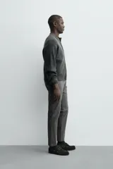Pantalón chino de corte ajustado, color beige, con bolsillos laterales y bolsillos traseros de vivo. Cuenta con cierre frontal de cremallera y botón.