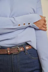 Buzo tejido color celeste, de manga larga, escote en V y tajitos en los costados.