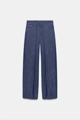 Pantalón confeccionado con lino de tiro alto con pliegues delanteros y cinco bolsillos. Presenta pernera holgada y cierre frontal con cremallera, botón interior y gancho.