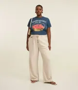 Pantalón recto de sarga en color crudo, diseñado para talles grandes (Curve & Plus Size). Presenta bolsillos laterales tipo cuchillo, cierre frontal con botones a la vista y un cinturón del mismo tejido con hebilla de efecto carey.