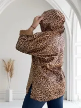 Buzo con capucha y cierre parcial con cremallera, de color marrón con estampado animal print y puños de piel sintética.