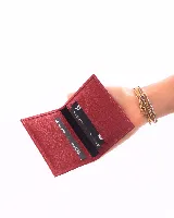 Tarjetero de cuero natural con textura granulada, color rojo, con diseño plegable y compartimentos internos para tarjetas.