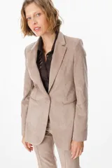 Blazer de corte clásico confeccionado en tela aterciopelada color bordó, con cuello solapa, cierre frontal con botones y bolsillos laterales tipo ojal.