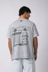 Remera negra con efecto acid wash, corte holgado y estampa frontal con logos y diseño de automovilismo.