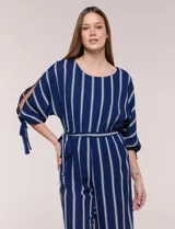 Enterito largo de crepe color azul marino con diseño de rayas verticales blancas. Cuenta con escote redondo, mangas tres cuartos con detalles de lazos en los puños, cintura elastizada con lazo extraíble para ajustar, bolsillos laterales y pantalón de corte amplio.
