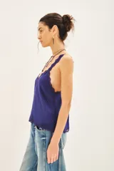 Top negro de viscosa con breteles finos y escote en V con puntilla. Presenta apliques de tachas termo adhesivas en el frente.