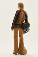 Polera de cuello alto confeccionada en lana lambswool, con diseño de bloques de color en tonos beige y marrón. Presenta mangas raglán con textura acanalada y detalles en hilo metalizado lurex.