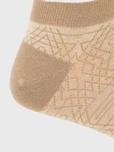 Calcetín corto para hombre de color beige con diseño geométrico tejido en tonos más oscuros. Talón y puntera reforzados en color beige sólido.