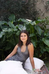 Vestido corto color fucsia con escote en V, breteles finos que se atan al cuello, corte a la altura de la cadera y falda acampanada con ruedo irregular.