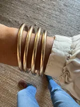 Set de pulseras circulares flexibles de estilo oriental, con acabado brillante en tonos dorados y plateados, rellenas de lámina metálica.