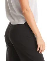 Pantalón wide leg de tiro alto con pierna ancha, confeccionado en tela con caída. Presenta cierre frontal con botón, pasadores para cinturón y bolsillos funcionales en la parte delantera y trasera.