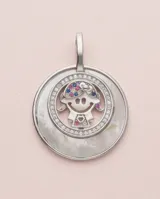 Dije circular de plata 925 con base de nácar y diseño central de figura infantil decorado con circonias multicolor.